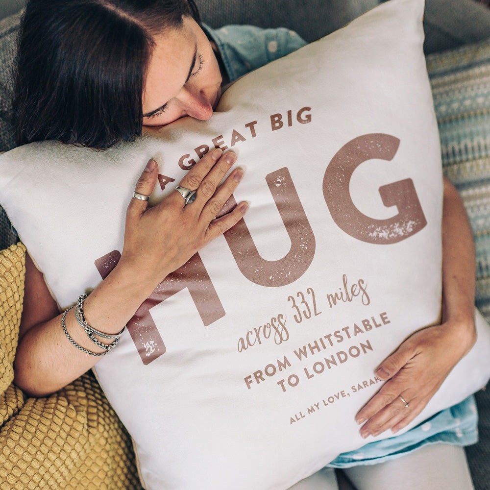 The image shows a personalised cushion stating the words 'a great big hug across 332 miles from Whitstable to London, all my love, Sarah'