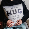 The image shows a man holding on tight to a personalised cushion. The words on the cushion say 'A great big hug across 180 miles Camberley to York. Love you Dad!