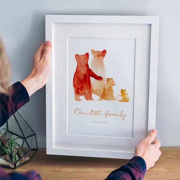 A custom family bear print in a white frame: The watercolour style illustrated family of bears show two parent bears, a child, and a baby bear. Underneath the customised words say 'Our Little Family - Since 2016'.