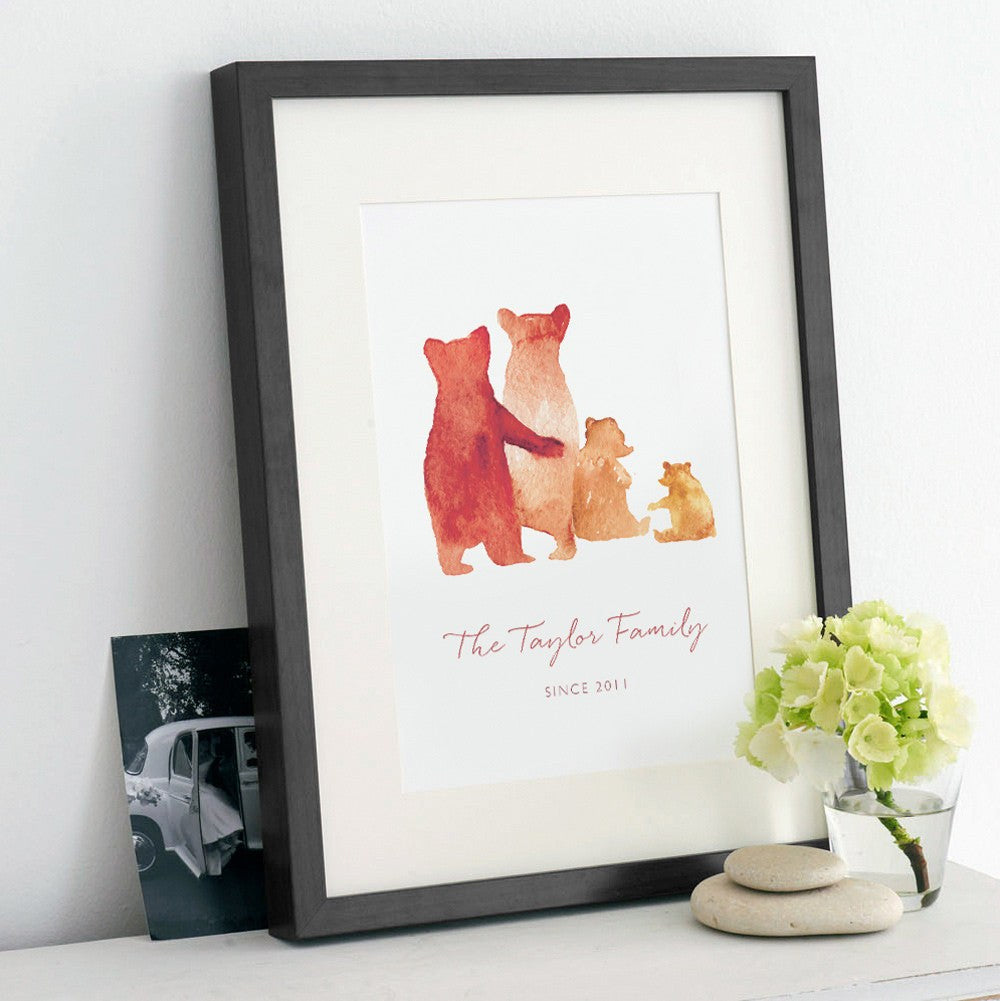 A personalised family bear print in a black frame: The watercolour style illustrated family of bears show two parent bears, a child, and a baby bear. Underneath the customised words say 'The Taylor Family - Since 2011'.