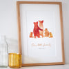 A custom family bear print in a black frame: The watercolour style illustrated family of bears show two parent bears, two child bears, and a baby bear in warm burnt orange. Underneath the customised words say 'Our little family - SINCE 2011'.