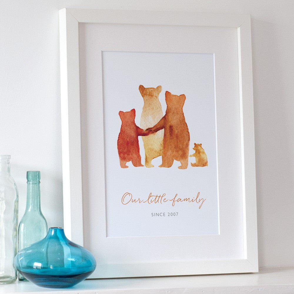 A custom family bear print in a white frame: The watercolour style illustrated family of bears show two parent bears, a teenage bear, and a baby bear. Underneath the customised words say 'Our little family - Since 2007'..
