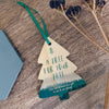 A Christmas Tree shaped decoration with the words 'a tree for your tree' in large text, followed with 'one tree planted as a gift to you & our planet' in smaller text underneath. Printed on bamboo, cut in to a classic Christmas tree shape. Photographed from above.