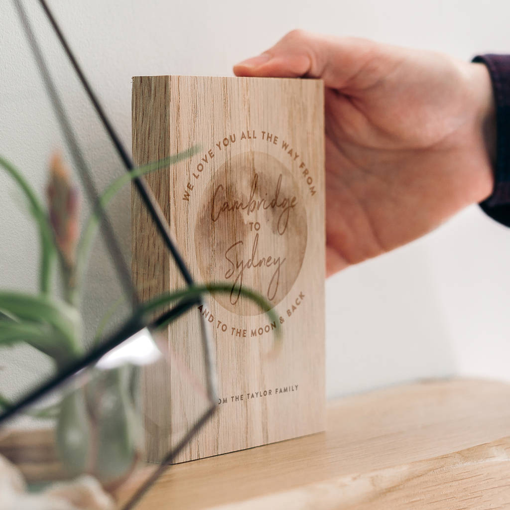 An oak wooden block with the words 'we love you all the way from Cambridge to Sydney and to the moon and back' featured around a picture of the moon. Underneath are the words 'from the Taylor family'.