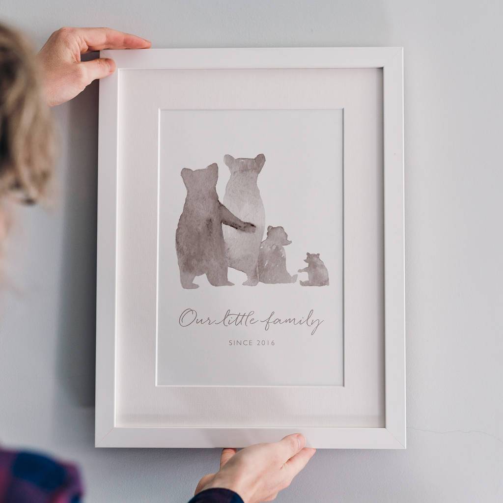 A personalised bear family print in a white frame: The watercolour style illustrated family of bears show two parent bears, a child, and a baby bear. Underneath the customised words say 'Our little family - since 2016'.