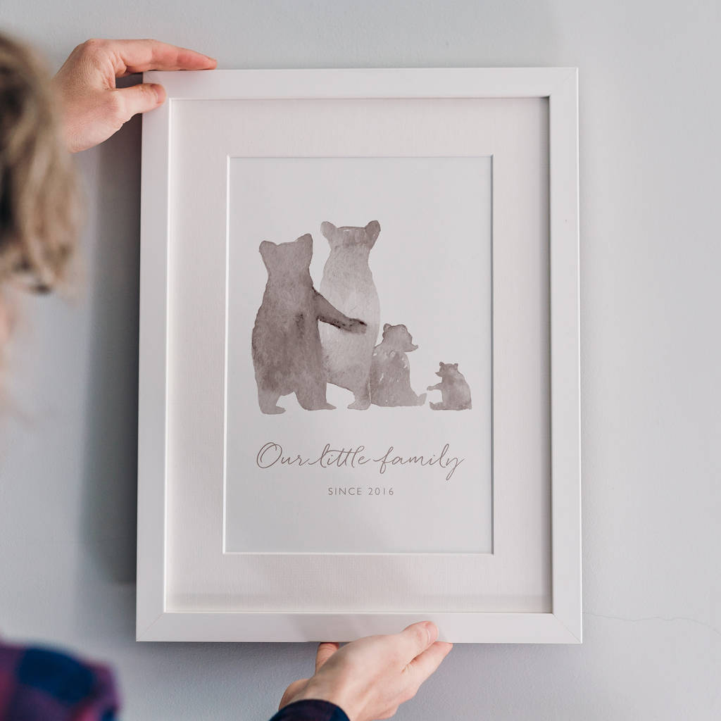 A customisable family bear print in a white frame: The watercolour style illustrated family of bears show two parent bears, a child, and a baby bear in soft grey. Underneath the personalised words say 'Our Little Family - Since 2016'.