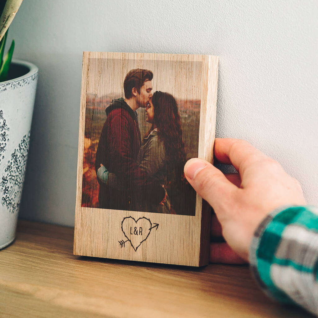 A customised photo block. Printed on to the solid oak block is a photo of a couple, underneath the photo there is an outline of a heart with the couples initials (L&R) inside.