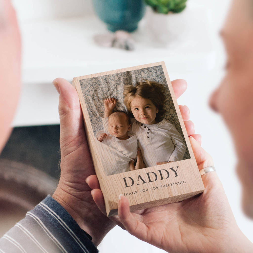 The image showcases a personalised photo block with a photo of a young child and their baby sibling printed on it. Underneath the photo on the block are the words 'Daddy, Thank you for everything'.