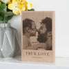 The image showcases a personalised solid oak photo block with a photo of a father and daughter touching noses printed on it. Underneath the photo on the block are the words 'true love, Ava & Daddy'.