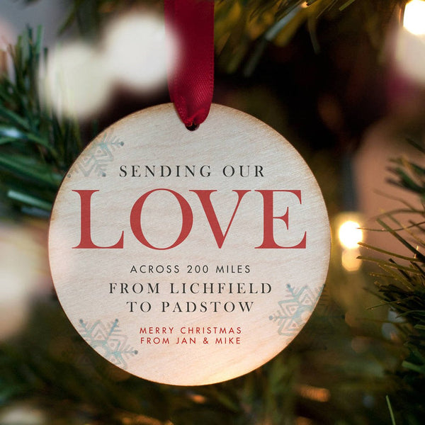 A personalised Christmas bauble with the words 'sending our love across 200 miles from Lichfield to Padstow. Merry Christmas from Jan & Mike'.