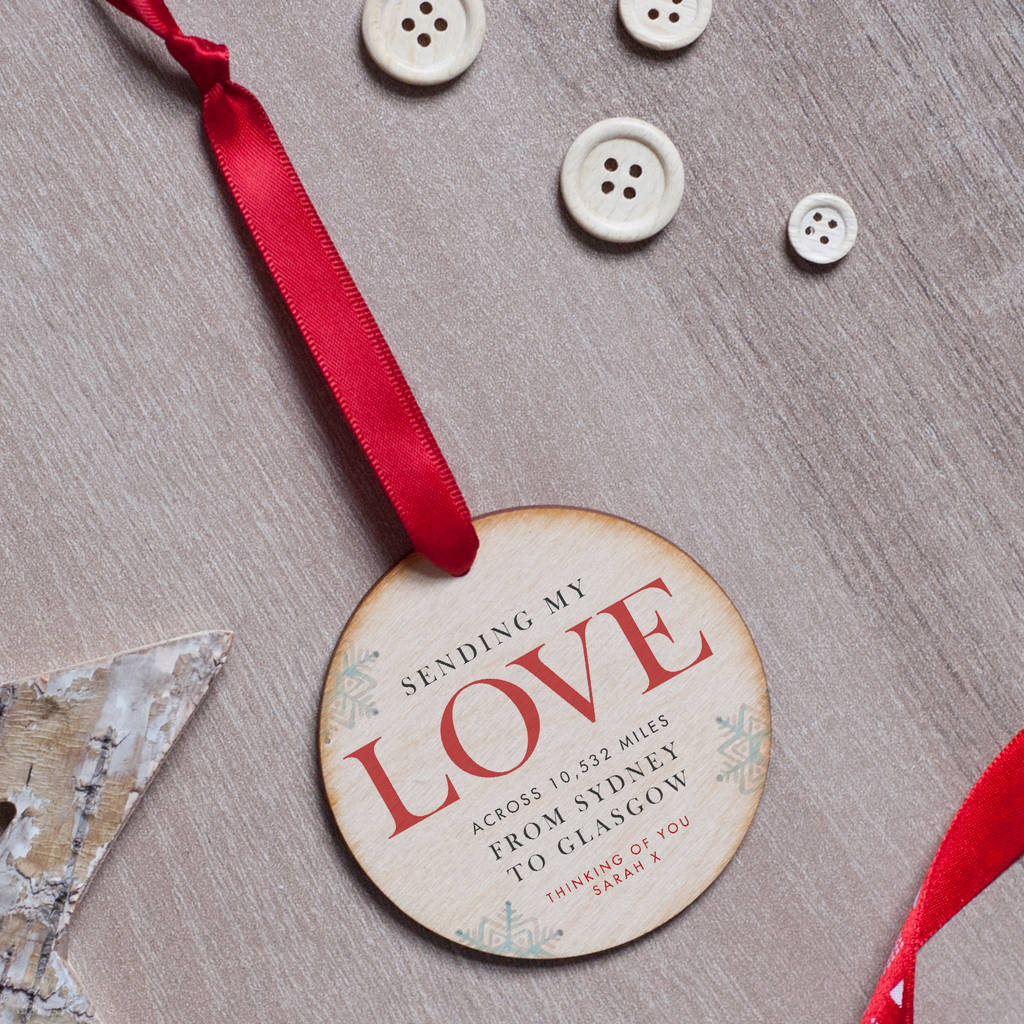 A personalised  wooden Christmas bauble with 'sending my love across 10,532 miles from Sydney to Glasgow' written on it.
