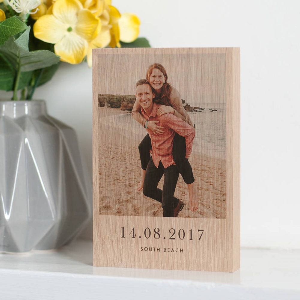 The image showcases a personalised photo block with a photo of couple having a piggyback at the beach printed on it. Underneath the photo on the block are the words '14.08.2017, South Beach'