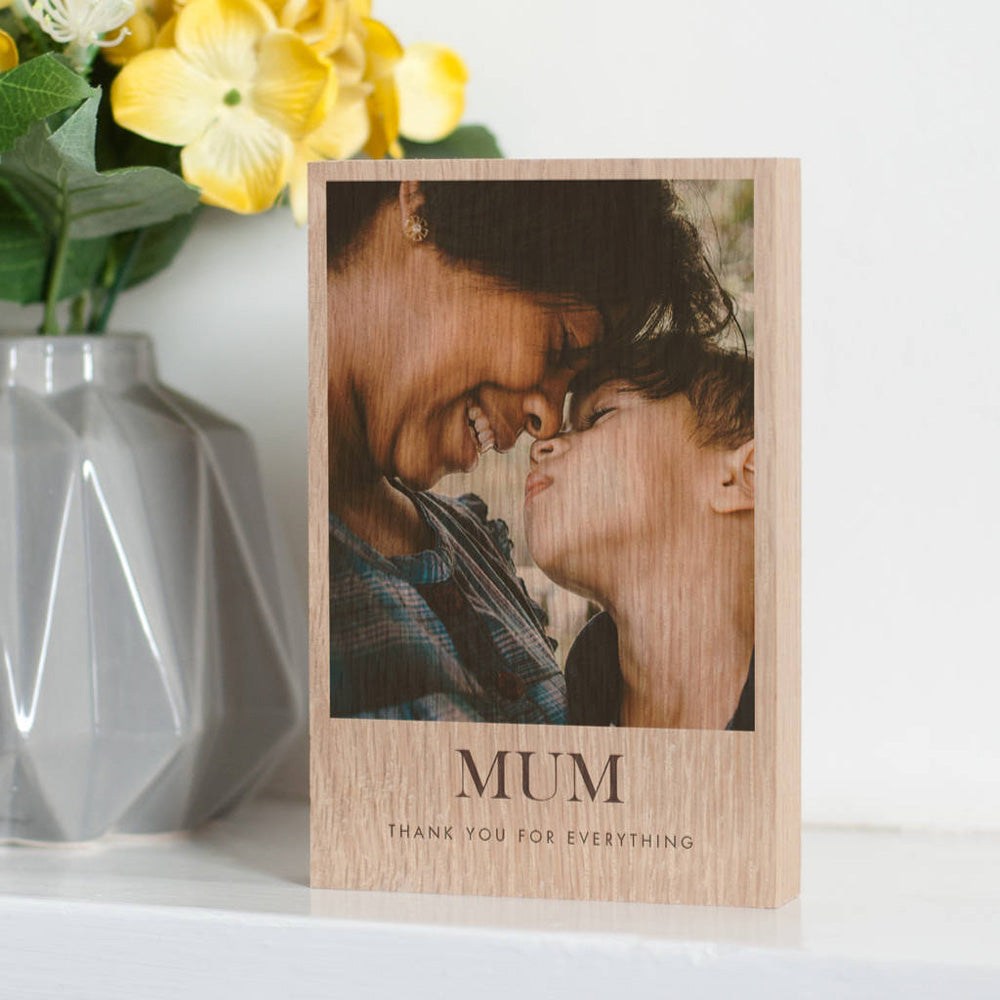 The image showcases a personalised photo block with a photo of a mother looking lovingly at her son printed on it. Underneath the photo on the block are the words 'Mum, Thank you for everything'.